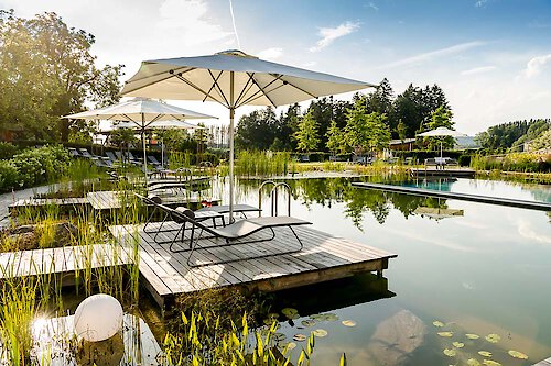 Naturbadesee mit Liegen und Sonnenschirme